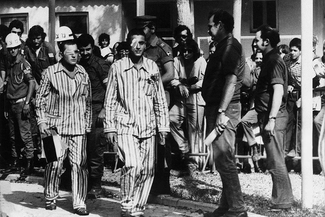 Israeli captives during the 1973 prisoner exchange, wearing striped civilian garments instead of military uniforms.